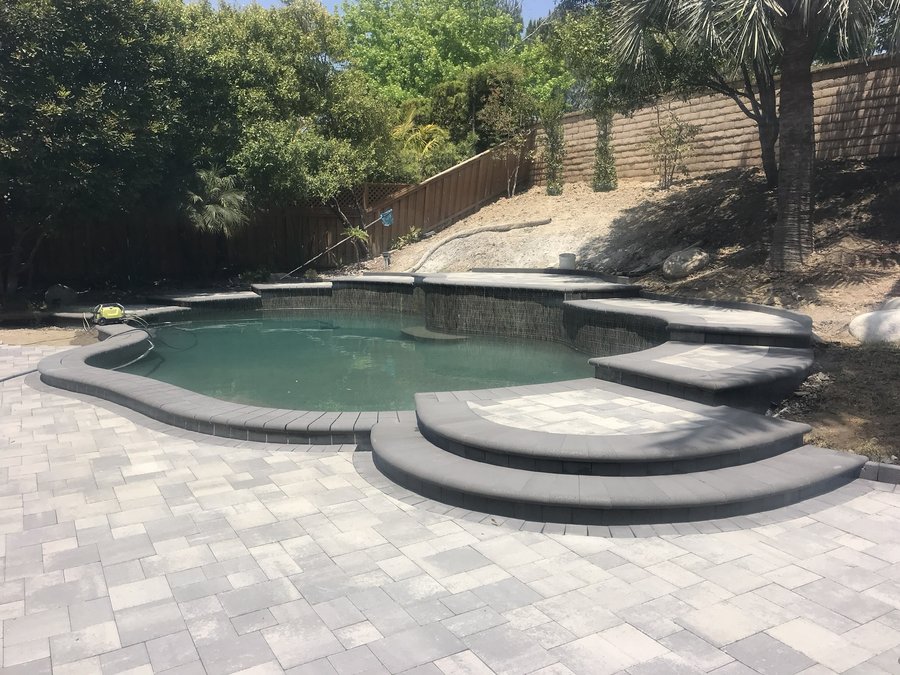 Rectangular pool with a paver deck and stone coping