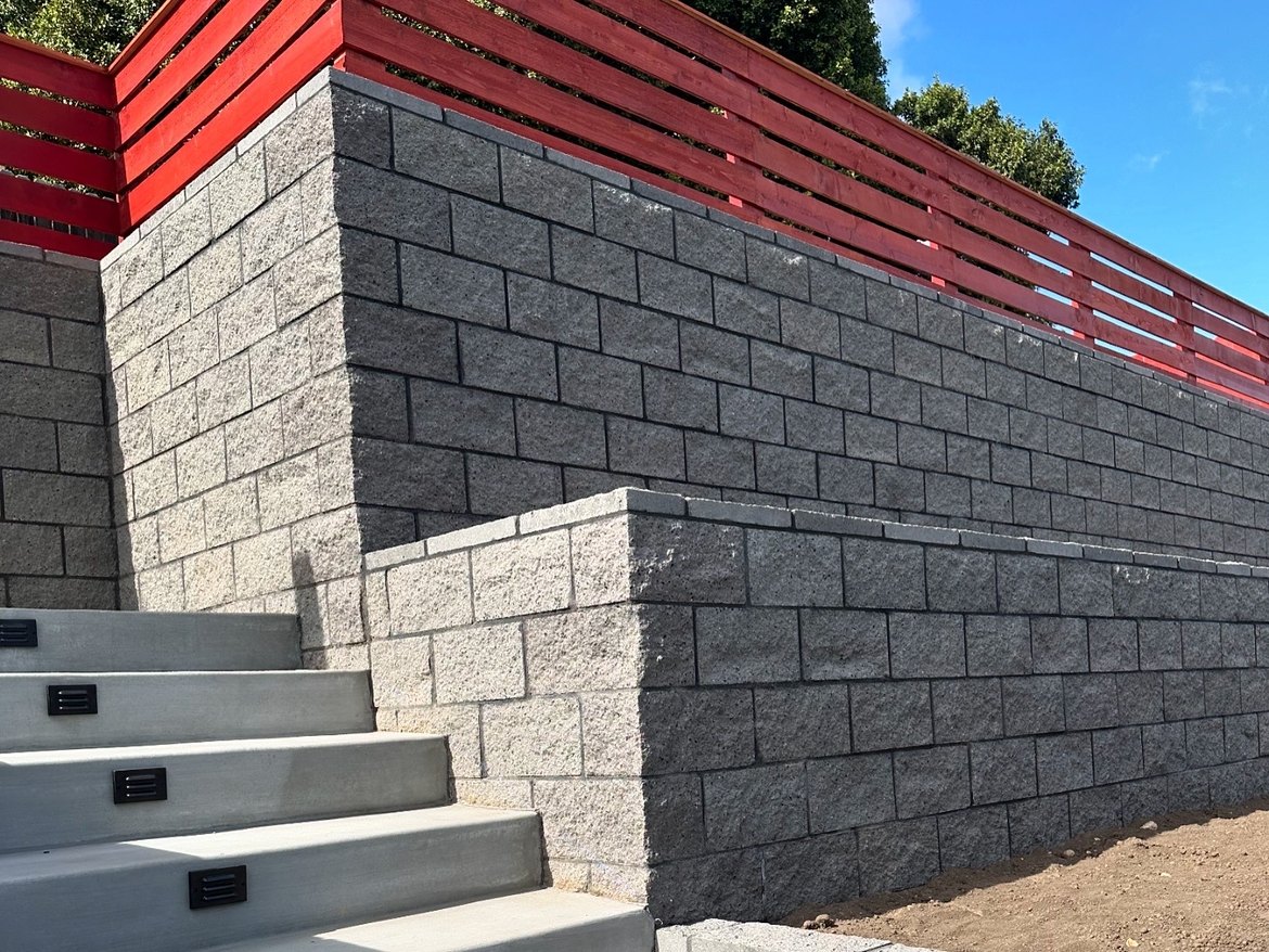 Tiered engineered block retaining wall with concrete steps